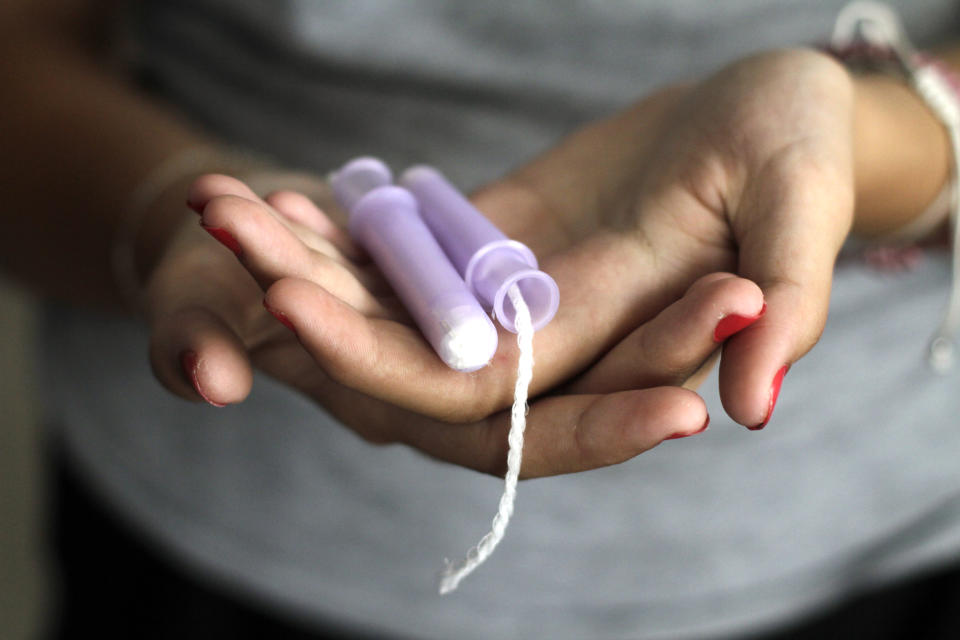 Close-up of a woman holding a tampon during a period.  (Photo via Getty Images)