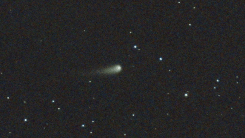 a blurry green comet in the night sky