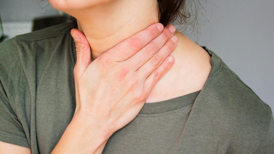 A postmenopausal woman touching her neck due to hot flashes.  (Photo via Getty Images)